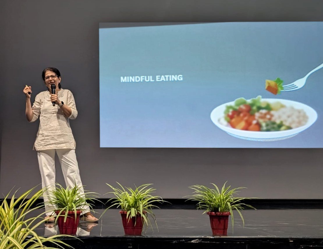 Shoba Shekar on stage teaching, with a Mindful Eating slide